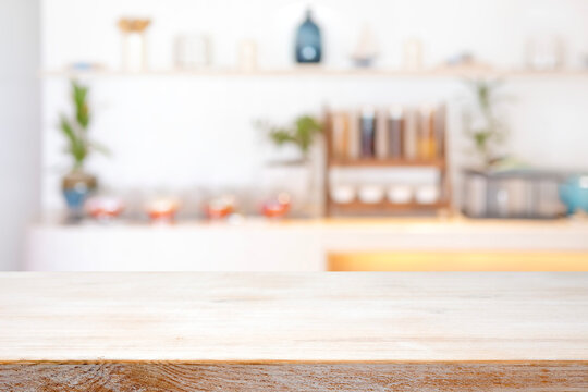 Empty bleached kitchen table front view on deeply blurred kitchen counter interior background