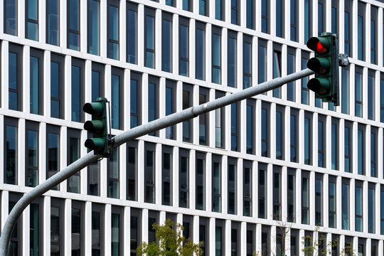 Modern urban architecture and building facade pattern behind traffic light signal at intersection showing city control and safety in daylight