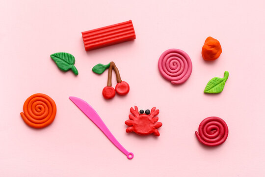 Many different colorful plasticine with figurines and plastic knife on pink background