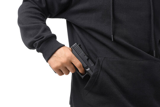 Man taking gun out from his hoodie pocket on white background