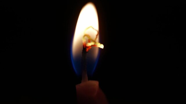Tiny figures dance in candle flame at night