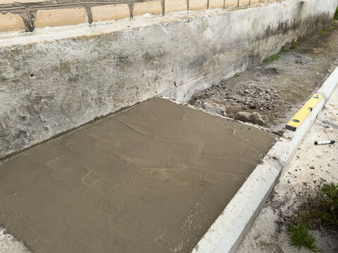 Fresh concrete surface drying inside foundation form after pouring