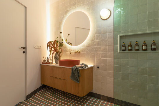 Modern Bathroom Interior with Pedestal Sink, Illuminated Mirror, Contemporary Design, and Styled Amenities for Home Decor