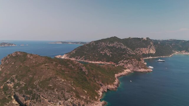Low Aerial Drone Flight Over Green Cliffs Towards Porto Timoni Beach in Corfu Greece