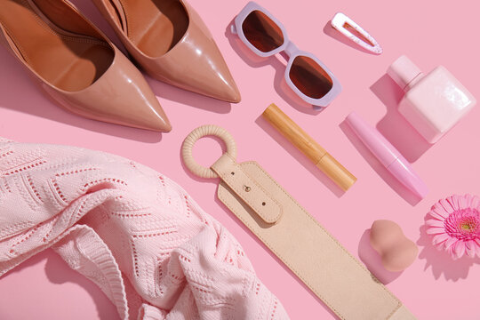 Composition with stylish female accessories, cosmetics and clothes on pink background