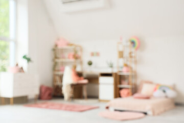 Obraz premium Blurred view of children's room with bed, study table and shelf units