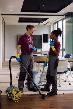 Cleaning staff members talking while maintaining office building.
