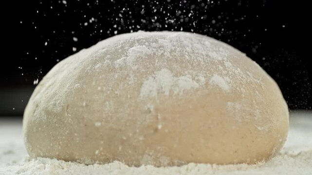 The dough on the kitchen table with falling flour . Filmed on a high-speed cinema camera at 1000 fps