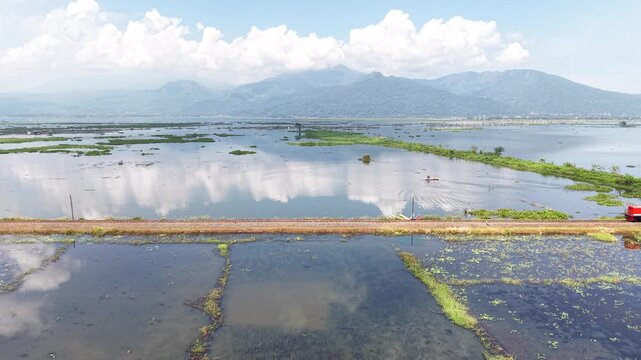 An aerial view of the Ambarawa Museum's vintage train journey across Lake Rawa Pening. A nostalgic journey using a diesel locomotive and classic wooden carriages.