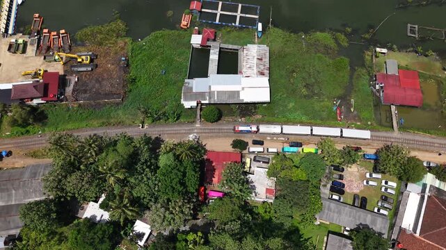 An aerial view of the Ambarawa Museum's vintage train journey, passing through Rawa Pening Lake and residential areas. A nostalgic journey using a diesel locomotive and classic wooden carriages.