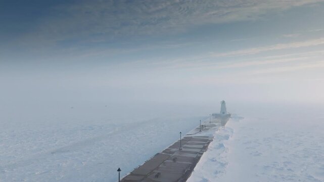 Smooth tracking shot showing the Port Maitland lighthouse against frozen Lake Erie.