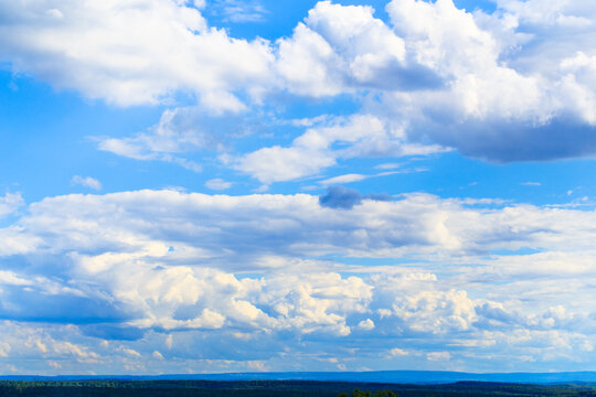 Clouds fill the sky over a vast landscape in a rural area during the daytime