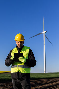 Wind Farm Engineer Using Tablet In Renewable Energy Field
