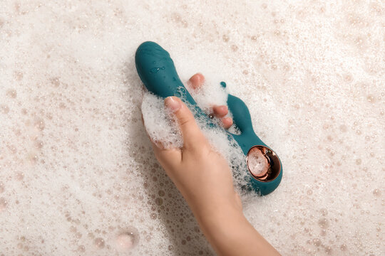 Woman washing green vibrator, closeup