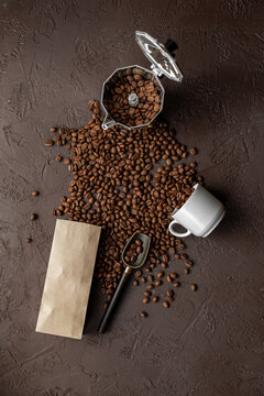 Silver geyser coffee maker with coffee beans from craft bag and in a cup on brown stone background, top view. Food concept photo