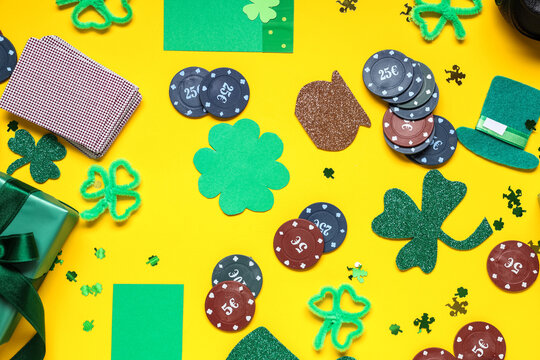 Composition with poker chips, cards and decorations for St. Patrick's Day celebration on yellow background
