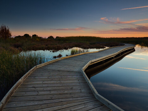 Pasarela de madera al atardecer en el humedal de la Marjal dels Moros, Valencia