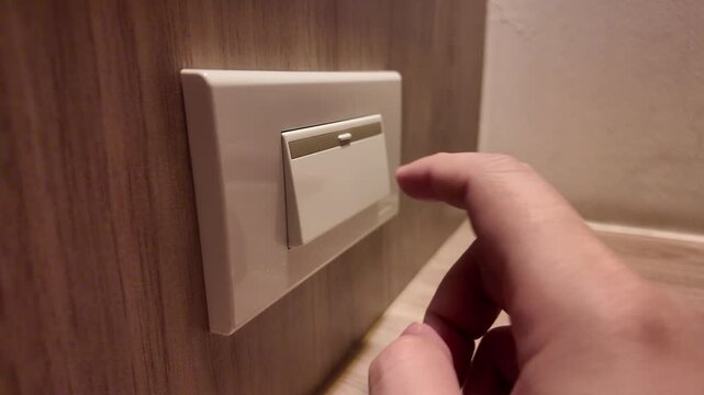 Slow motion of hand pressing a light switch to turn lights off in the bedroom. Concept of energy saving, and power efficiency. 4K horizontal resolution