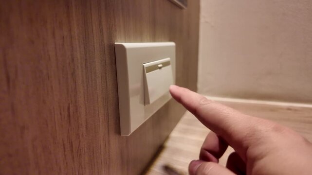 Slow motion of hand pressing a light switch to turn lights off in the bedroom. Concept of energy saving, and power efficiency. 4K horizontal resolution