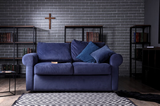Interior of living room with Holy Bible on sofa and bookshelves
