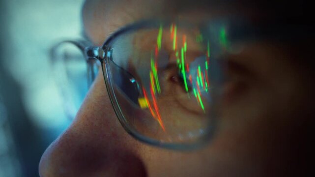 Under neon glow stock exchange, bespectacled male broker hunches over his PC, scrutinizing flickering candlestick chart as price fluctuations surge. Nighttime focus sharpens his data-driven analysis