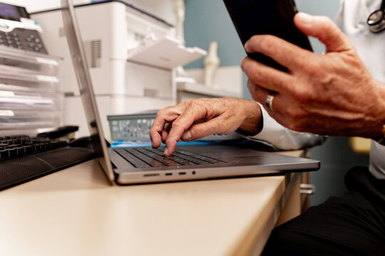Multitasking at desk with laptop and smartphone