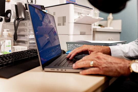 Staff member typing on laptop in office workspace