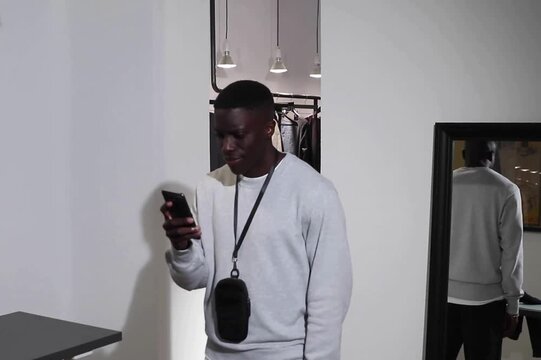 Man carefully inspecting sweatshirt sleeve details while shopping for quality basics in store