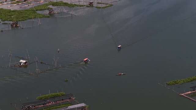 An aerial view of fishing boats and tourist boats crossing Rawa Pening Lake, a lake in Semarang Regency, Central Java, located in the basin of Mount Merbabu, Telomoyo, and Ungaran.