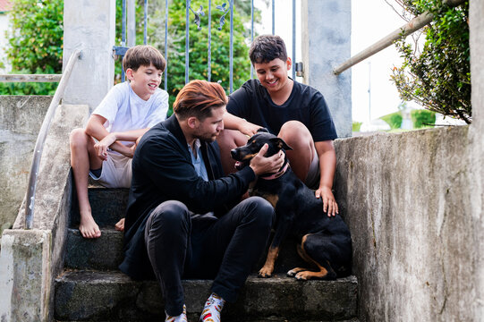 Kelpie dog sitting on concrete steps with pet owners