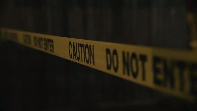 Yellow caution do not enter tape at night restricting closed area creating atmosphere of danger and strict access control during dark nighttime environment