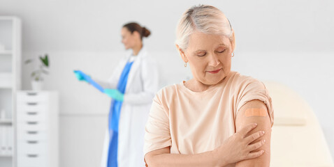 Fototapeta premium Senior woman with medical patch after vaccination in clinic