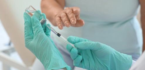 Fototapeta premium Female doctor vaccinating senior woman in clinic, closeup