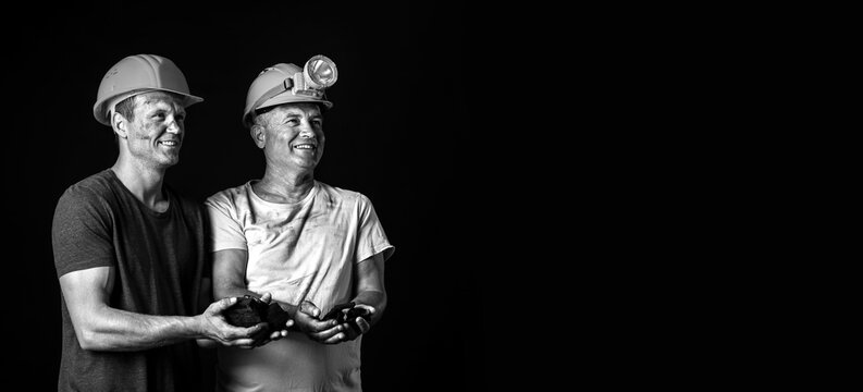 Miner men with coal on dark background with space for text
