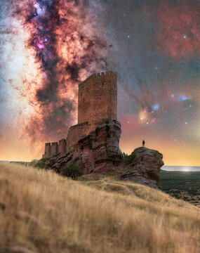 Astrophotography Panorama of Zafra Castle with Majestic Milky Way and Human Silhouette
