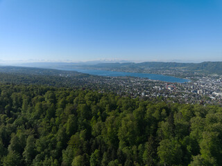 Naklejka premium Aerial view of Swiss city of Zürich with woodland and blue sky background on a sunny spring morning. Photo taken April 30th, 2026, Zurich, Switzerland.