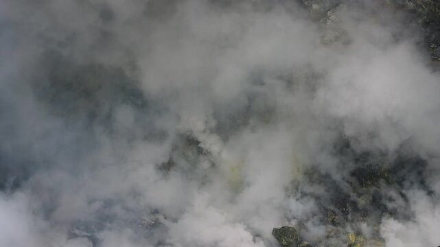 A close-up view of an active volcanic crater filled with thick white steam and smoke rising from fumaroles Mount Bromo in East Java, Indonesia