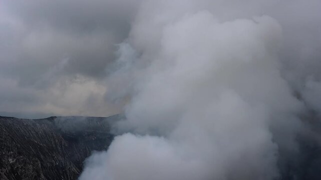A dramatic volcanic landscape dominated by massive clouds of thick white steam rising from an active crater  Mount Bromo in East Java, Indonesia