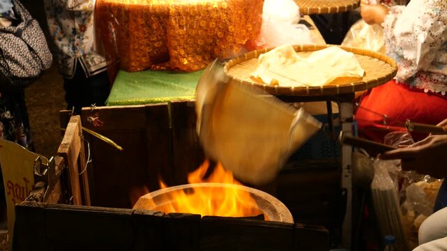 Grilling traditional Thai rice cracker