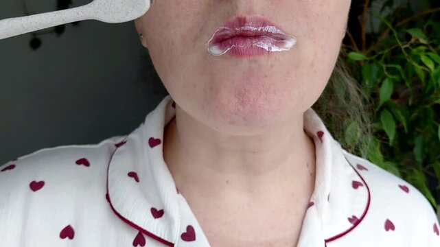 A woman brushes her teeth in close-up