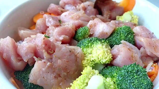 Vegetables with meat are placed in a baking dish. Cooking turkey, broccoli, carrot and onion fricassee with cream