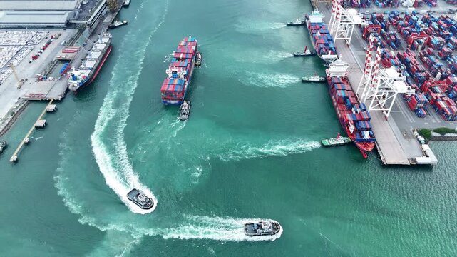 Multiple tugboats maneuvering large container ships into a busy commercial port terminal. Active maritime logistics, supply chain infrastructure, and international freight trade operations.