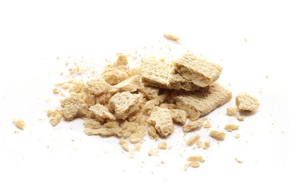 Pile crumbs and pieces broken wholemeal crispy rye bread isolated on white background, side view