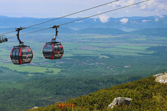 Tatranska Lomnica, Slovakia - May 25, 2024: Cable cars on its way from Skalnate pleso to Lomnicky stit and in the opposite direction with beautiful landscape on background