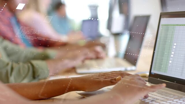 Team typing at laptops, typing sparking code overlays over hands and screen showing business table