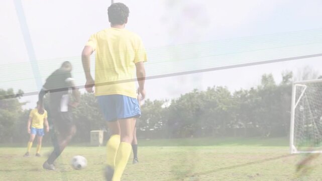 Sports attacker in yellow kit driving into area, shooting ball, GK diving, team celebrating goal