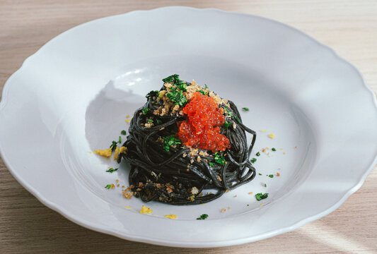 Black pasta with cuttlefish ink and red caviar, served with breadcrumbs fried in olive oil. Volcanic inspiration, seafood paste