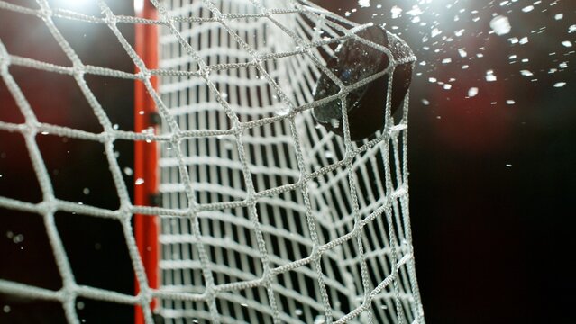 An ice hockey puck hitting the back of the net