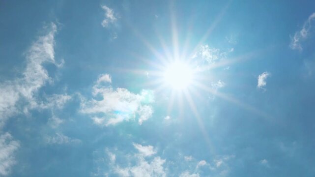 Bright sun sunlight sun rays sunbeams daylight azure blue sky and few fluffy white clouds, aerial view, time lapse, slow motion, sunny blue sky white clouds and sun.  