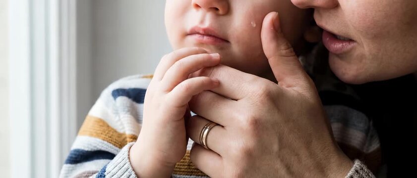parent child hands comfort reassurance care support closeness trust safety protective touch near the face highlights soothing presence and empathy for parenting guidance and wellbeing campaigns
